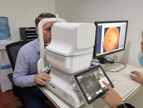 DrTono Vista Station used for a patient fundus examination while the clinician reviews the captured retinal image on an external monitor.